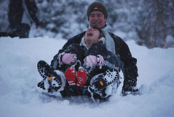 Adult and child sledging down hill