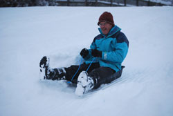 Adult racing downhill in an EcoSledge sledge