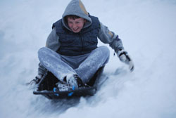 Teenager racing downhill in an EcoSledge sledge