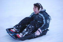Teenager racing downhill in an EcoSledge sledge